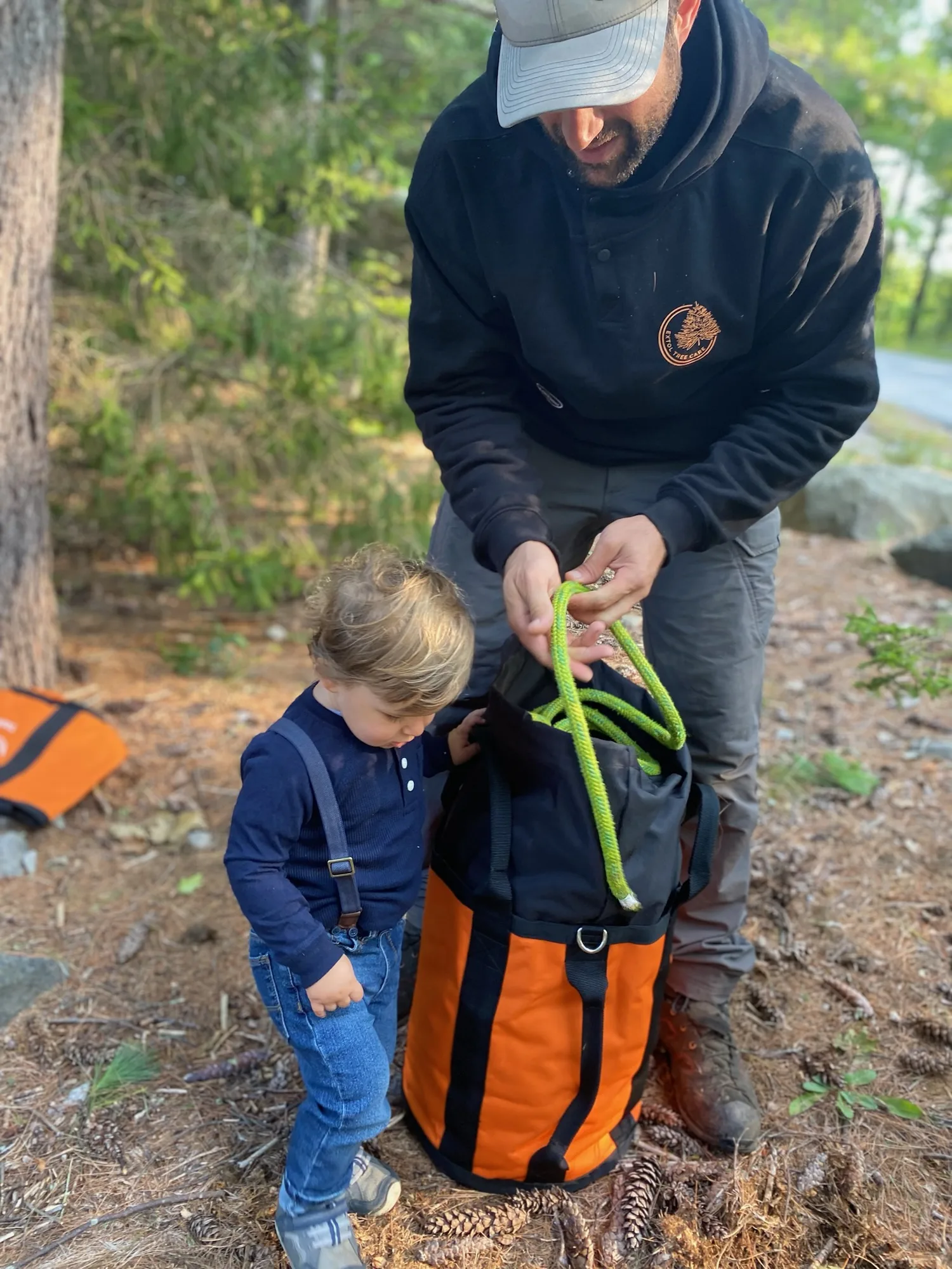 Arborist and child packing climbing ropes together